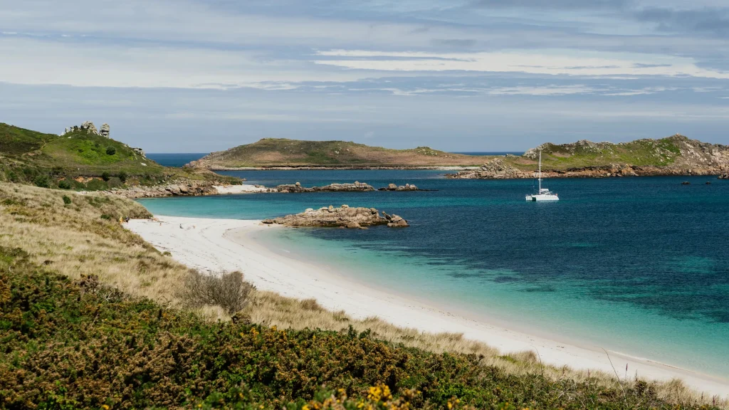 White sand and turquoise water at Great Bay, St Martin's, with a catamaran at anchor